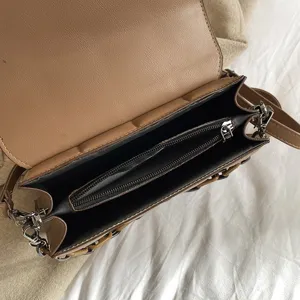 Stylish brown leather shoulder bag with multi-compartment interior for daily women fashion.