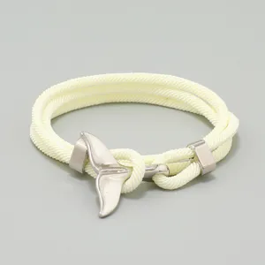 Detailaufnahme des einfachen ozeanischen Milan-Linien geflochtenen Armbands mit Walfisch-Anhänger.