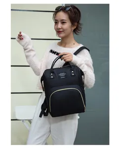Vue détaillée du sac à dos à langer noir multifonctionnel avec des compartiments spacieux.