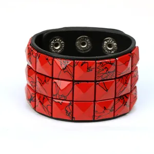 Pulsera de cuero ancha estilo punk con tachuelas cuadradas rojas y botones de presión metálicos.