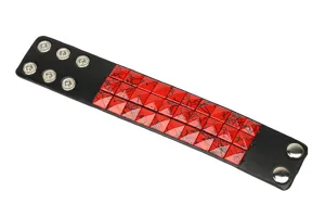 Primer plano detallado de pulsera de cuero ancha punk con remaches cuadrados rojos.