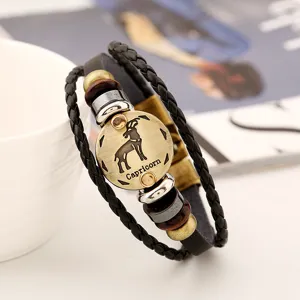 Detalle de la pulsera de cuero trenzado multicapa vintage con dije de metal de Capricornio.
