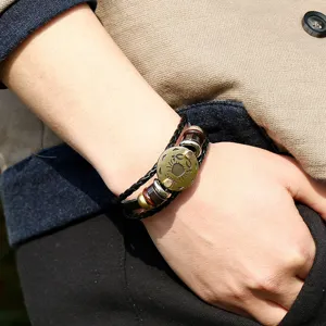 Primer plano detallado del brazalete de cuero trenzado vintage con colgante del zodiaco.