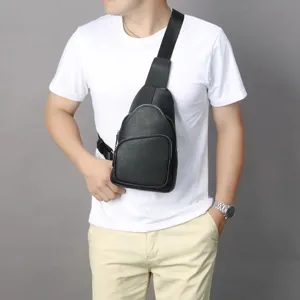 Detailed view of a black leather chest bag worn across the body, featuring durable zippers.