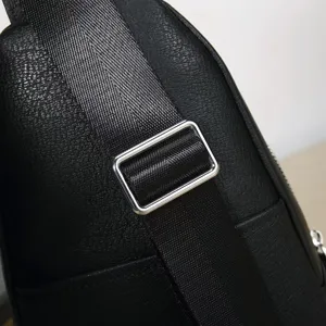Close-up detail shot of the adjustable shoulder strap and leather texture on a fashion black chest bag.