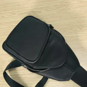 Detail view of black leather chest bag for men and women, casual sling backpack, daily use fashion accessory.
