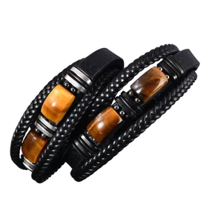 Close-up of multi-layer leather bracelet with tiger eye stone and metallic decor for men.