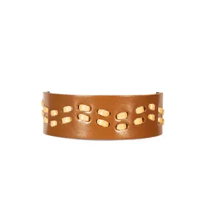 Gros plan détaillé du bracelet manchette en cuir marron large avec des coutures beiges rétro.