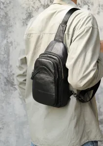 Detailansicht der schwarzen Herren Leder Brusttasche im urbanen Freizeit Szenenstil.