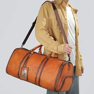 Primo piano di una borsa da viaggio in pelle marrone vintage con texture e tracolla.