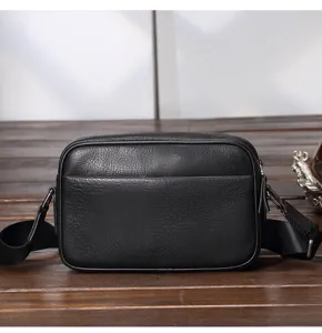 Black leather crossbody phone bag detail showing premium texture, zipper and fabric strap.