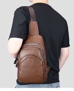 Detail view of brown genuine leather chest bag for men, featuring convenient zipper pockets.