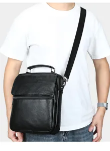 Vista detallada del bolso bandolera de cuero negro para hombre llevado por el modelo.