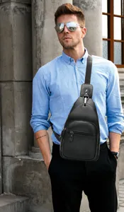 Detail view of genuine leather chest bag for men, casual sling shoulder bag in black color.