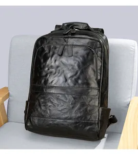 Close-up view of the black textured leather backpack showing the front zipper pocket.