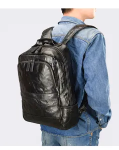Detailed shot of men black leather backpack showing texture, zipper and strap details.