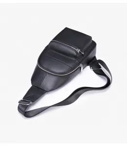 Close-up detail of black leather men's chest bag with metal zippers and adjustable strap.
