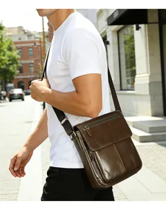 Vue détaillée d'un élégant sac à bandoulière en cuir marron foncé avec une texture fine.
