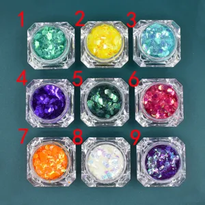 Vista dall'alto di nove barattoli di paillettes iridescenti per nail art e fai da te