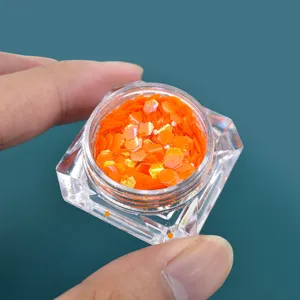 Dettaglio di glitter esagonali arancioni cangianti per nail art e creazioni in resina