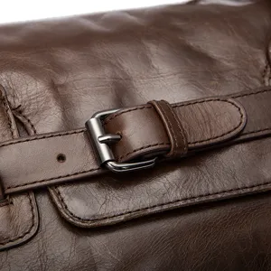 Gros plan sur la boucle du sac de voyage en cuir marron véritable, texture vintage.