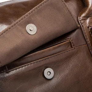 Gros plan détaillé d'un sac de voyage en cuir marron vintage avec bouton aimanté.