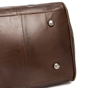 Gros plan sur le fond du sac de voyage en cuir marron avec rivets métalliques et coutures.