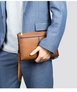 Vue detaillee de la pochette en cuir marron pour homme, texture souple et fermeture eclair.