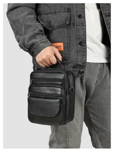 Detailed view of the black leather men shoulder bag with multiple zippered pockets and handle.