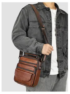 Close-up detail of multi-pocket brown leather men's crossbody bag with adjustable strap.