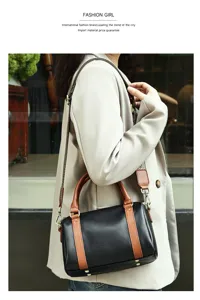 Detailed view of women leather boston bag with contrast handles and chic crossbody strap.