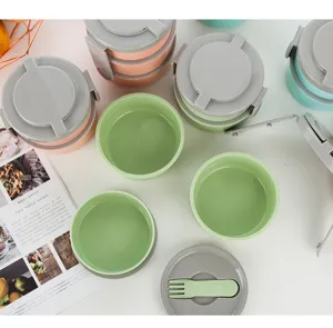 Detalle de fiambrera portátil multicapa con compartimentos y recipientes de comida coloridos.