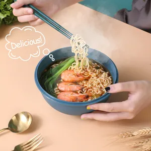 Detail shot showing ramen noodles with shrimp and vegetables inside a blue bowl being lifted with chopsticks.