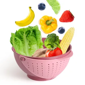 Kitchen double layer plastic draining basket close-up, pink fruit vegetable washing colander.