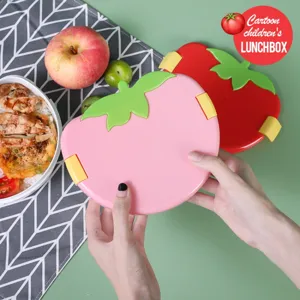 Close-up van de schattige tomaatvormige kinderbrooddoos met handige sluitingen voor dagelijks.