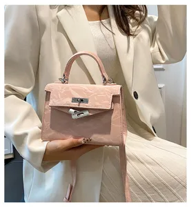 Vista detallada del elegante bolso de mano rosa texturizado para mujer con cierre de metal.