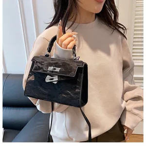 Elegante bolso de mano negro estructurado con cierre de giro metálico para mujeres a la moda.