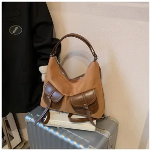 Vintage brown suede shoulder bag with dual front pockets and retro casual hobo design.