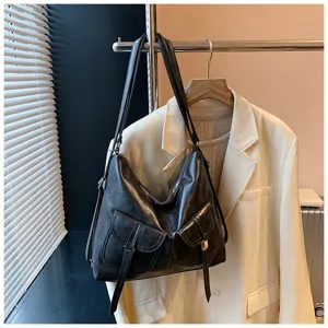 Vintage black leather shoulder bag detail, stylish hobo tote with dual pockets for women.