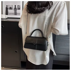 Gedetailleerde opname van een stijlvolle zwarte dameshandtas voor crossbody met handvat.