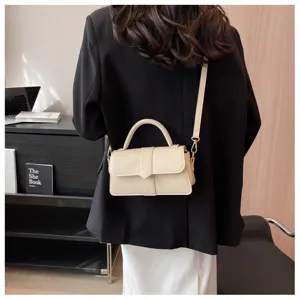 Gedetailleerd overzicht van een chique beige schoudertas met handvat, stijlvol accessoire.