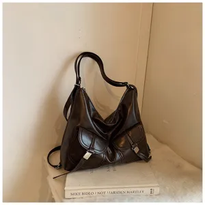 Detailed shot of dark brown vintage motorcycle style shoulder bag with dual front flap pockets.