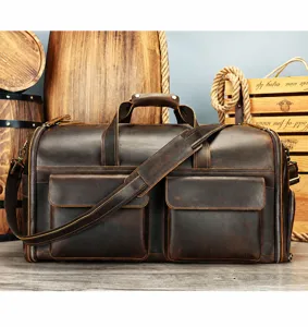 Detail shot of vintage crazy horse leather travel duffel bag with multiple pockets and straps.