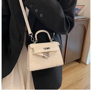 Vista detallada del bolso Kelly beige elegante puesto, mostrando cuero fino y herrajes metálicos.