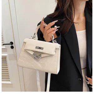 Elegante bolso de mano blanco con diseño trapezoidal clásico y cierre de metal elegante.