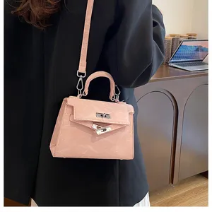 Detalle de bolso bandolera Kelly rosa, elegante bolso de mujer con cierre de metal.