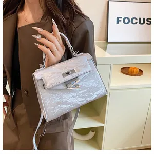 Detalle exquisito del bolso Kelly plateado arrugado con textura premium y herrajes de lujo.