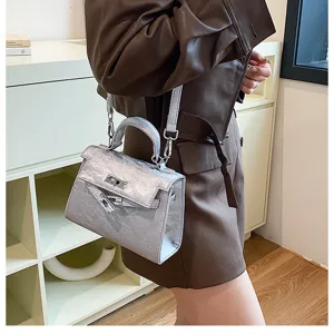 Detalle del bolso Kelly texturizado plateado, con elegante herraje metálico y asa chic.