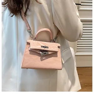 Vista detallada del bolso de hombro rosa estilo Kelly con cierre metálico elegante.