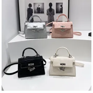 Bolso de mano mini elegante con forma trapecio clásica, asa superior y correa ajustable.